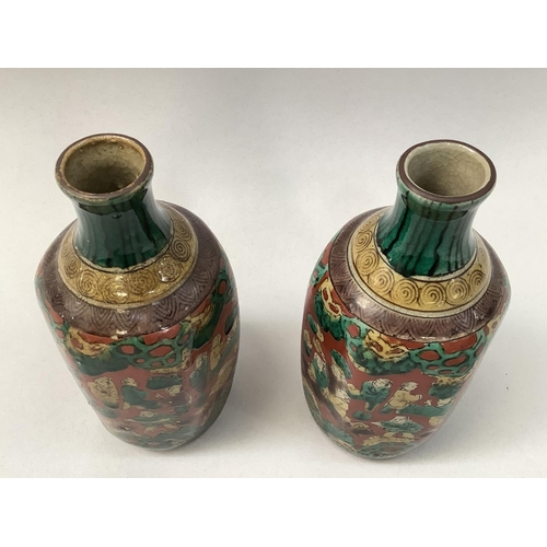 32 - A pair of Japanese pottery vases of hexagonal outline, the buff ground painted with multiple figures... 