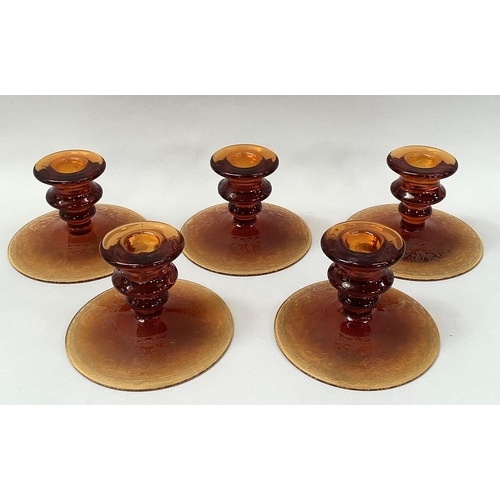 36 - A set of five amber glass candlesticks on circular domed bases, etched with a scrolled border 12.5cm... 