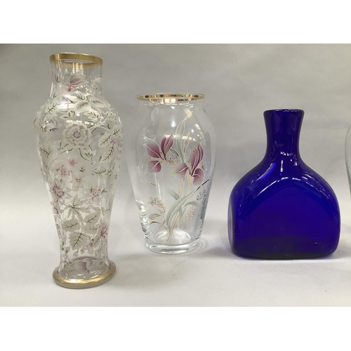 55 - A pair of clear glass vases printed in white, pink, green and gilt with flowers measuring 28.5cm hig... 