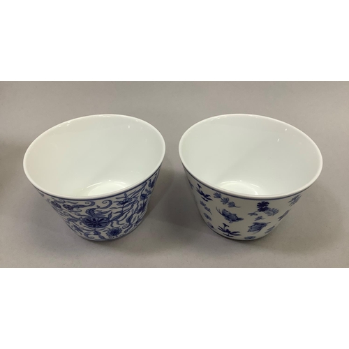 50 - A pair of Jingdezhen porcelain bowls/cups, each with blue insect and foliate design, each with chara... 