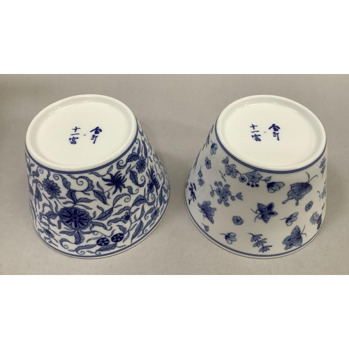 50 - A pair of Jingdezhen porcelain bowls/cups, each with blue insect and foliate design, each with chara... 