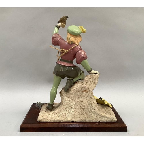 47 - A cast iron and enamelled figure of a huntsman on a rocky outcrop with a bird on his hand and one lo... 