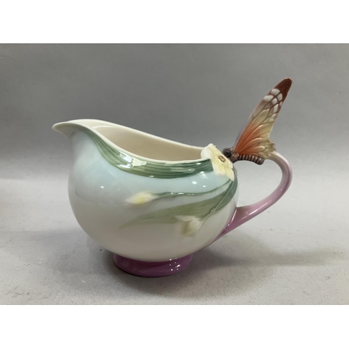 25 - A Franz porcelain butterfly design cup and saucer with spoon set and a butterfly cream jug with orig... 