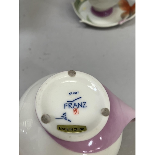 25 - A Franz porcelain butterfly design cup and saucer with spoon set and a butterfly cream jug with orig... 