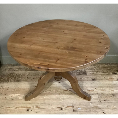 57 - A modern pine circular dining table on vase turned pedestal and four downswept legs, 105cm diameter,... 