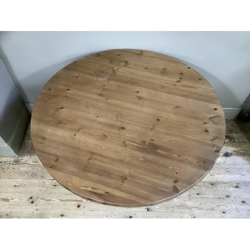 57 - A modern pine circular dining table on vase turned pedestal and four downswept legs, 105cm diameter,... 