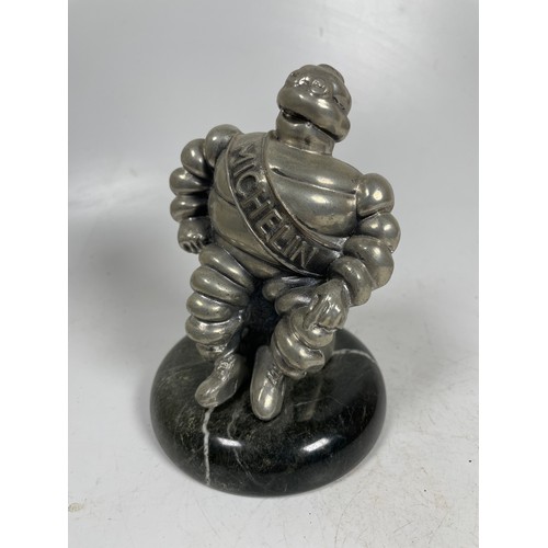 2 - A vintage car mascot in the form of the Michelin Man in seated position mounted on a marble effect b... 