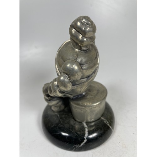 2 - A vintage car mascot in the form of the Michelin Man in seated position mounted on a marble effect b... 