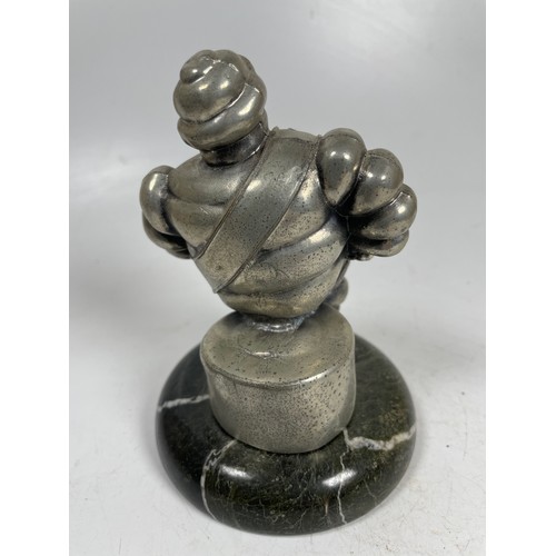 2 - A vintage car mascot in the form of the Michelin Man in seated position mounted on a marble effect b... 