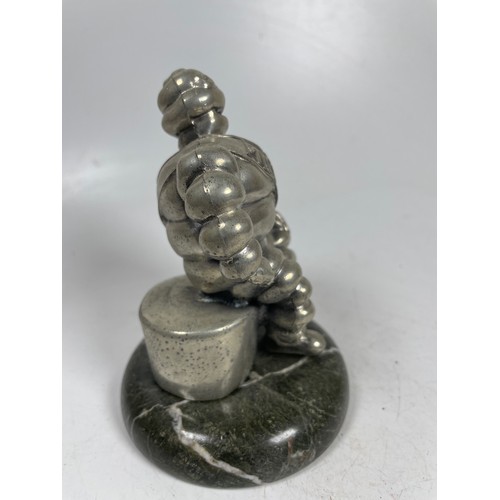 2 - A vintage car mascot in the form of the Michelin Man in seated position mounted on a marble effect b... 