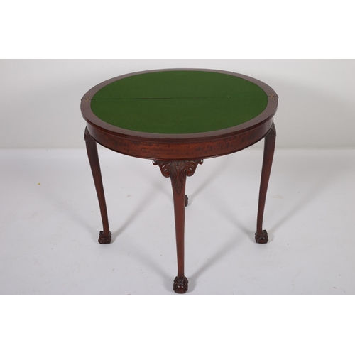 33 - A GEORGIAN DESIGN MAHOGANY FOLD OVER CARD TABLE of demilune outline the shaped top with carved rim a... 