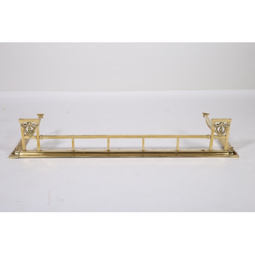 35 - A BRASS FENDER the square top rail raised on square uprights flanked by conforming uprights with rib... 