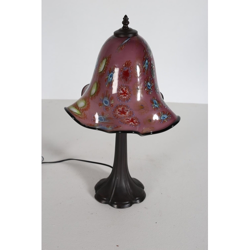 104 - AN ART DECO DESIGN BRONZED TABLE LAMP with multicoloured glass shade raised on a spreading foot 55cm... 