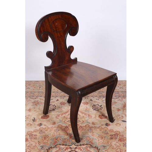 24 - A REGENCY MAHOGANY HALL CHAIR the shield shaped back with panelled seat on reeded sabre legs