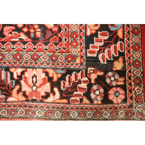 3 - A LILIAN WOOL RUG the wine ground with central stylized floral panel within a conforming border 235c... 