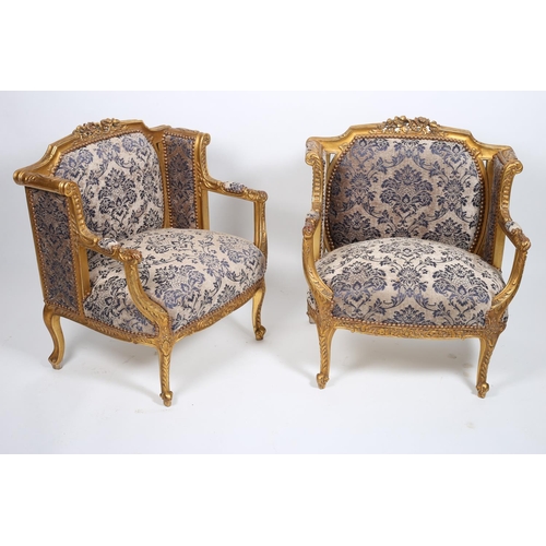 34 - A PAIR OF CARVED GILTWOOD AND UPHOLSTERED ARMCHAIRS each with a foliate carved top rail above an uph... 