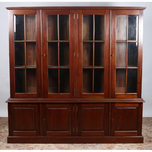 64 - A MAHOGANY CHINA DISPLAY CABINET the moulded cornice above four glazed doors and cupboards on platfo... 