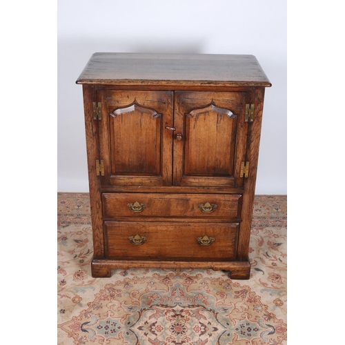 69 - A JACOBEAN DESIGN OAK SIDE CABINET of rectangular outline with panelled doors above two long drawers... 