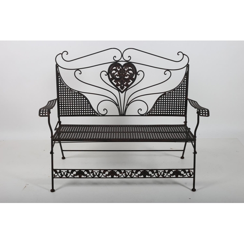 74 - A WROUGHT IRON TWO SEATER FOLDING GARDEN BENCH with scroll and lattice work decoration on pad feet 1... 