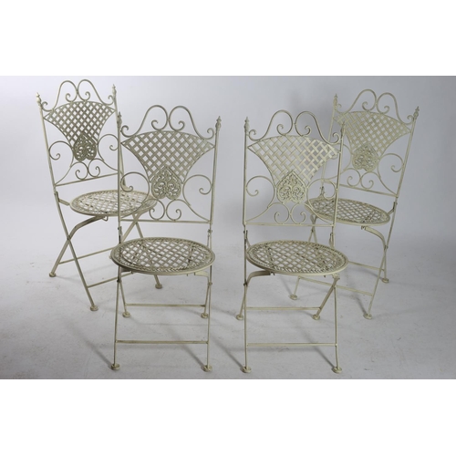 75 - A SET OF FOUR WROUGHT IRON GREEN PAINTED FOLDING GARDEN CHAIRS with lattice back splat and seat on p... 