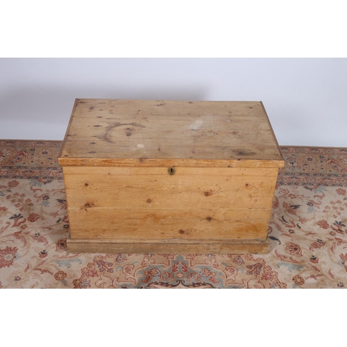 80 - A VINTAGE PINE TRUNK of rectangular outline the hinged lid with vacant interior on platform support ... 