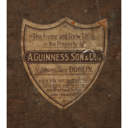 226 - Guinness's Stout, 1923 advertising sign, on wood panel, the black background centered with a Guinnes... 