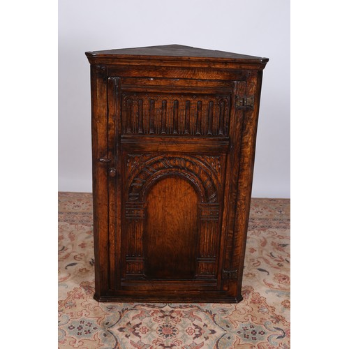 70 - A JACOBEAN DESIGN CARVED OAK SIDE CABINET of rectangular outline with canted angles and panelled doo... 