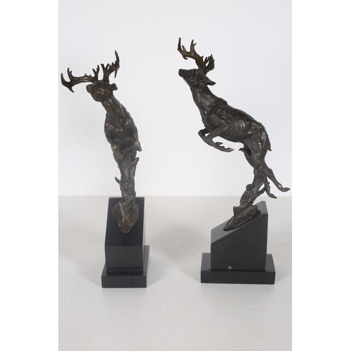 102 - AFTER MILO A PAIR OF CAST BRONZE FIGURES modelled as Stag's shown leaping raised on shaped black mar... 