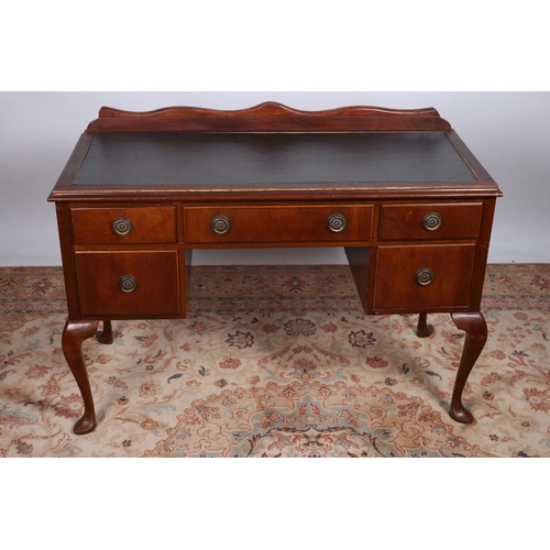 73 - A QUEEN ANNE DESIGN MAHOGANY DESK of rectangular outline with rexine writing surface above one long ... 