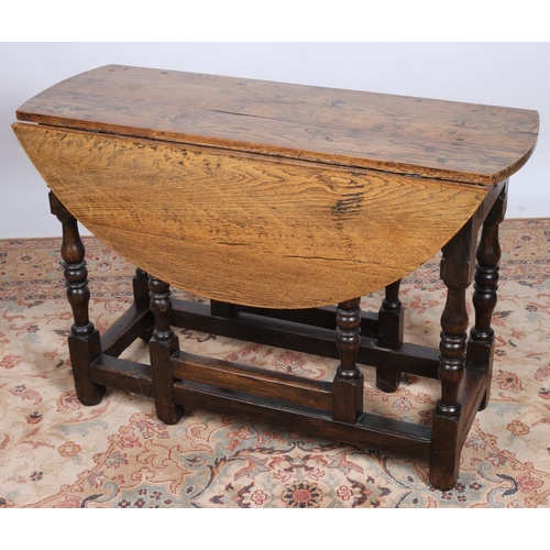92 - A 19TH CENTURY OAK DROP LEAF TABLE the oval hinged top with frieze drawer on baluster legs joined by... 