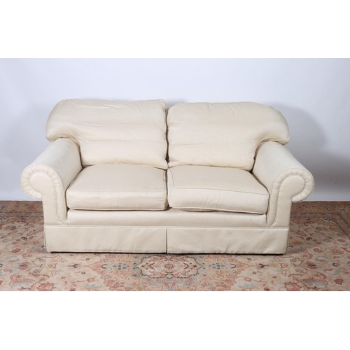17 - A WHITE UPHOLSTERED TWO SEATER SETTEE with scroll over arms 86cm (h) x 182cm (w) x 96cm (d)