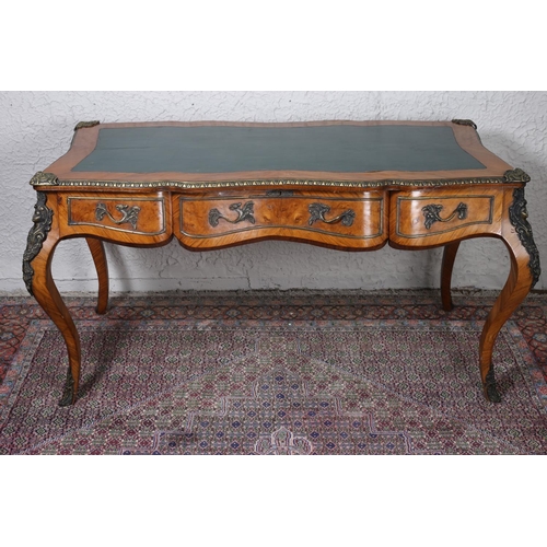 33 - A CONTINENTAL WALNUT AND GILT BRASS MOUNTED BUREAU PLAT of serpentine outline with tooled leather in... 