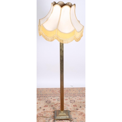 34 - A BRASS CORINTHIAN COLUMN FLOOR STANDING LAMP with reeded column above a square stepped base on claw... 