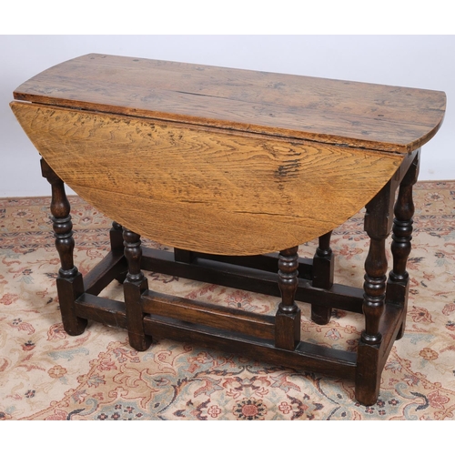 36 - A 19TH CENTURY OAK DROP LEAF TABLE the oval hinged top with frieze drawer on baluster legs joined by... 