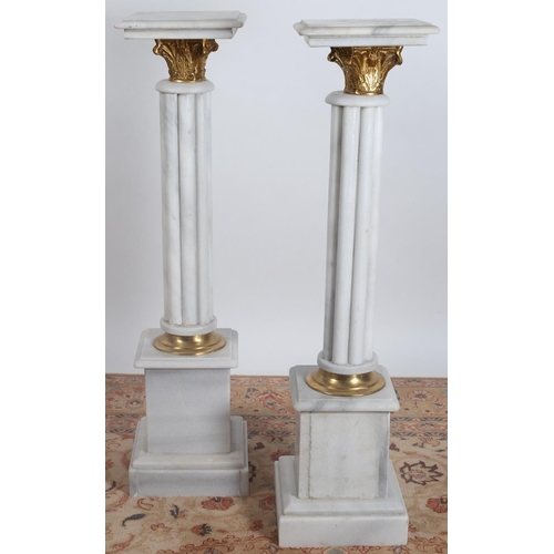 38 - A PAIR OF WHITE VEINED MARBLE AND GILT BRASS COLUMNS each with a square stepped top above a cluster ... 
