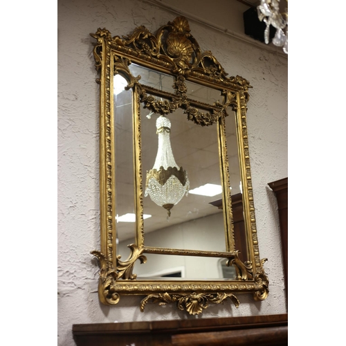 45 - A CONTINENTAL GILT FRAME COMPARTMENTED MIRROR the rectangular bevelled glass plate within an egg and... 