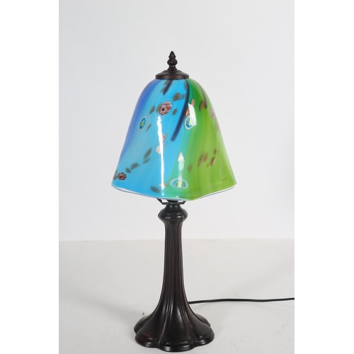 49 - AN ART DECO DESIGN BRONZED TABLE LAMP the multicoloured glass shade above a stylized foliate column ... 