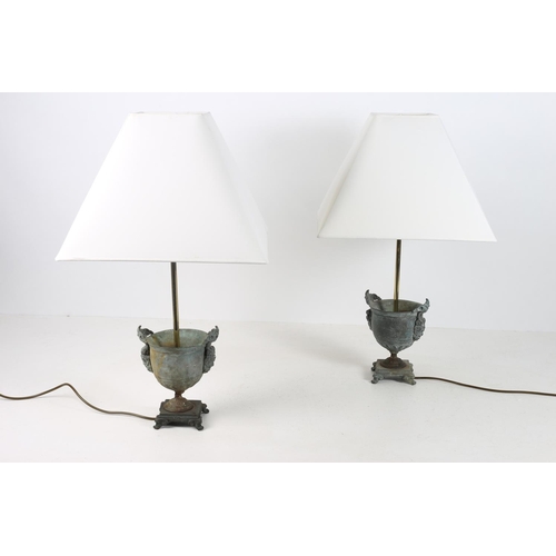 51 - A PAIR OF BRONZE TABLE LAMPS each of urn form with figural mask handles above a circular foot on rec... 