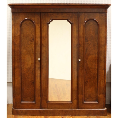 53 - A GOOD VICTORIAN WALNUT THREE DOOR WARDROBE the moulded cornice above a central mirrored door flanke... 