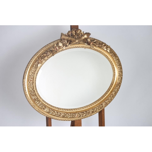 575 - A CONTINENTAL GILT FRAME MIRROR the oval bevelled glass plate within a foliate decorated frame with ... 