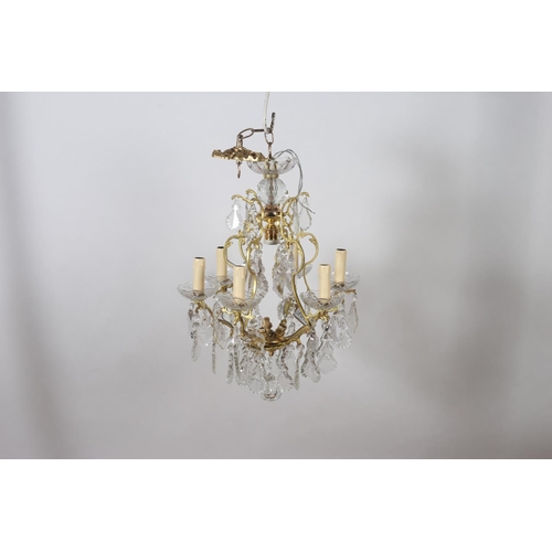 582 - A CONTINENTAL GILT BRASS AND CUT GLASS SIX BRANCH CHANDELIER the open work frame hung with pendent d... 