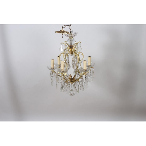 583 - A CONTINENTAL GILT BRASS AND CUT GLASS SIX BRANCH CHANDELIER the open work frame hung with pendent d... 