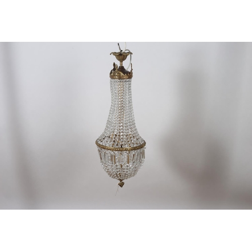 584 - A CONTINENTAL GILT BRASS AND CUT GLASS TWO BRANCH CENTRE LIGHT hung with cascading faceted pendants ... 