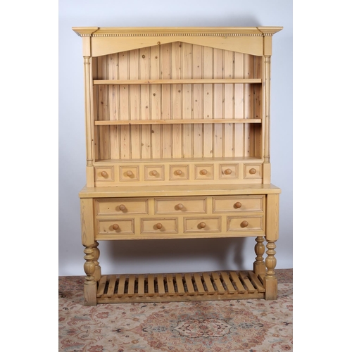 585 - A PINE OPEN FRONT DRESSER of inverted breakfront outline the moulded cornice above three open shelve... 