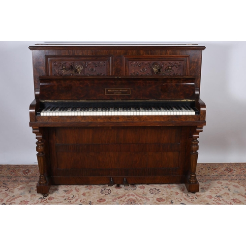 64 - A VICTORIAN WALNUT CASE UPRIGHT PIANO with carved panels and brass sconces bears label Mornington & ... 