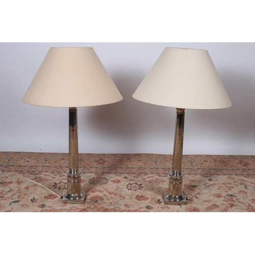 86 - A PAIR OF CONTEMPORARY SILVER PLATED TABLE LAMPS each with a cylindrical column raised on square bas... 