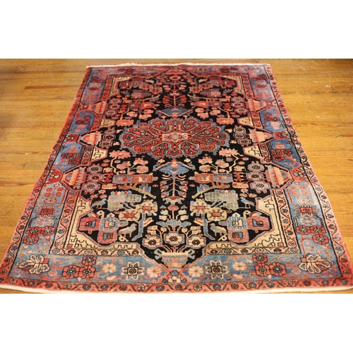 11 - AN ORIENTAL WOOL RUG the indigo light blue and light pink ground with central panels filled with sty... 