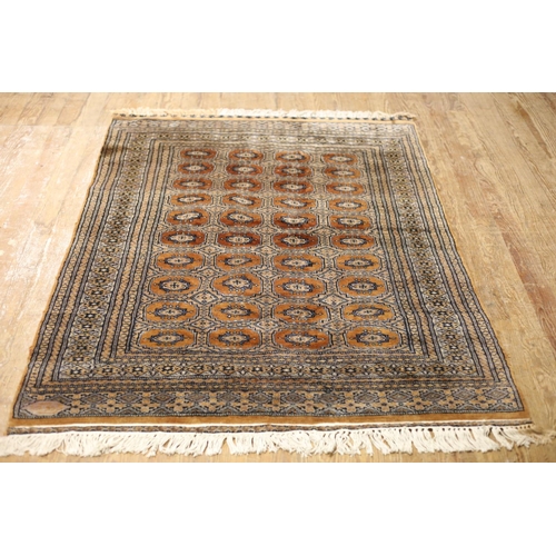 472 - AN ORIENTAL WOOL RUG the light brown and gold ground with central panel filled with diamond shaped a... 