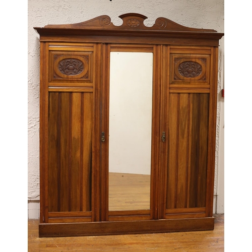 1 - AN EDWARDIAN MAHOGANY THREE DOOR WARDROBE the moulded cornice above a mirrored door containing slide... 