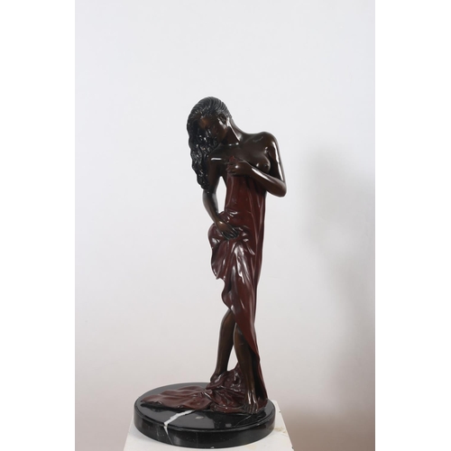 19 - A BRONZE AND PAINTED FIGURE modelled as semi clad female with drapery shown standing on a circular m... 